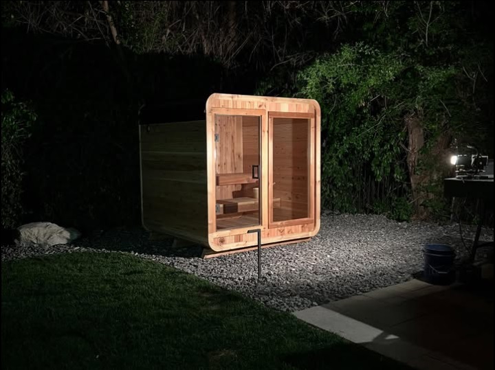 Illuminated cube sauna at night